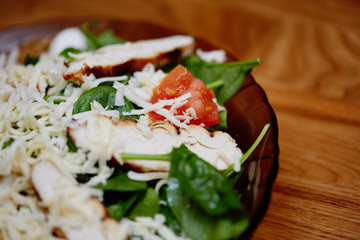 salad with cheese, chicken, spinach, tomato