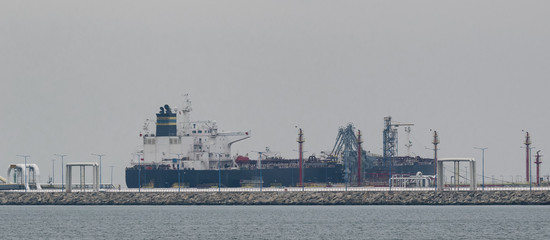 Obraz premium OIL TERMINAL - Big tanker and seaport fuel waterfront infrastructure