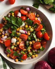  healthy vegetable salad of chickpeas, corn, cherry tomatoes, cucumbers, red onions for vegetarians