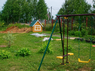 children's swing on a rural plot in summer, Russia.