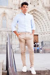 young European guy in blue shirt walking around city