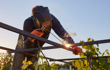 Worker welder working welding steel in industry with safety mask