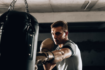 Young caucasian Boxer training with a punching bag in his home gym