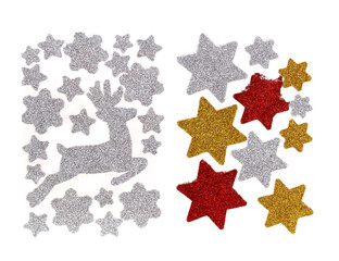 Set of glitter Christmas stickers isolated on a white background. They are white, gold and red stars and running Christmas reindeer. We can decorate gifts or Christmas cards