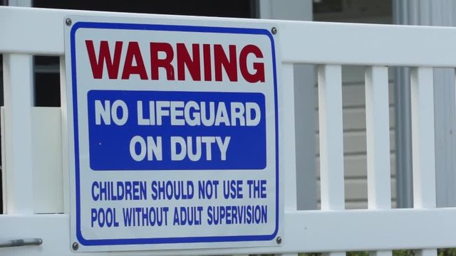 Warning sign at pool, no lifeguard.