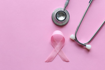 Obraz na płótnie Canvas Pink ribbon and stethoscope on pink background, Symbol of breast cancer in women, Health care concept