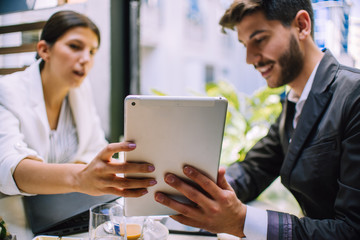 Portrait of two young business colleagues sitting at coffee shop