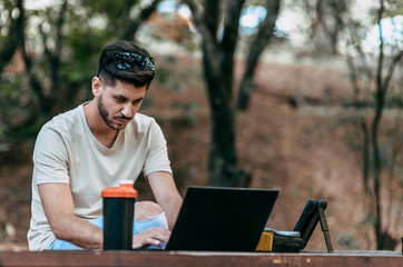 Obraz premium Freelancer man with notebook sitting on the park bench