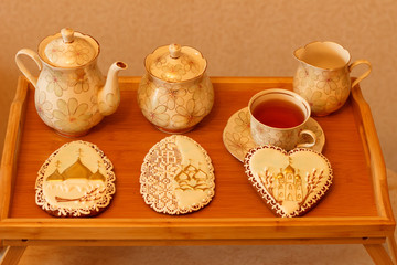 Tea set on a wooden table with handmade Easter gingerbread cookies.