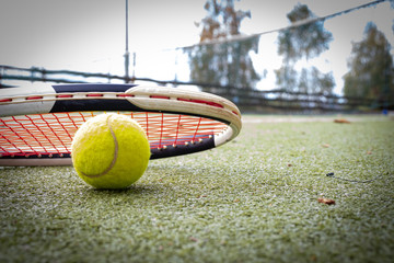 Tennis racket and a ball on grass court