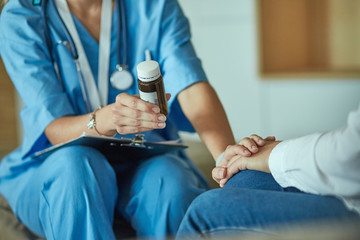 Beautiful smiling woman the doctor in a bottle of pill offers t