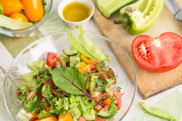 Vegan vegetarian food, fresh salad with vegetables in plate on table