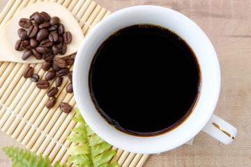 Coffee in a cup and coffee beans on the table
