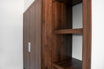 Modern brown wooden wardrobe in the room.