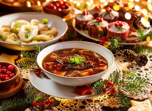 Christmas mushroom soup, a traditional vegetarian  mushroom soup made with dried forest mushrooms in a ceramik plate on a festive table. Polish Christmas dinner