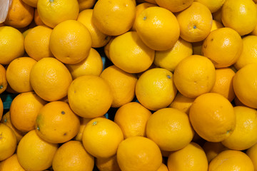 A lot of yellow lemons on a market as a texture or background. Lemon harvest. Healthy and vitamin food. Citrus fruits.