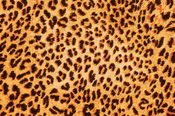 Black spots of different shapes on orange background - background as leopard skin