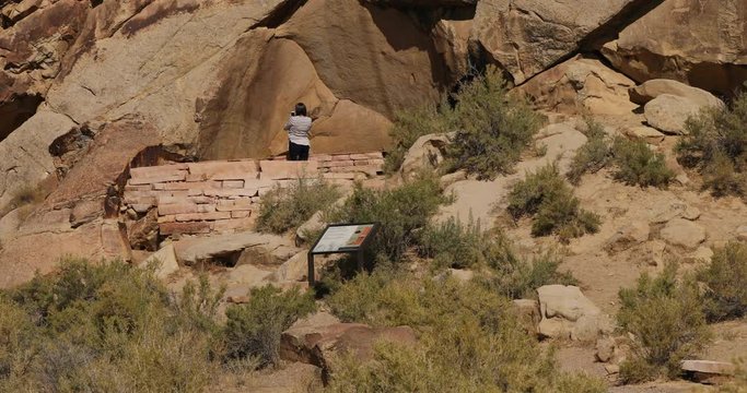 Woman explores Indian village ancient rock art Utah. World’s longest art gallery of ancient native American, Indian rock art, hieroglyphs, pictographs and petroglyphs in area.