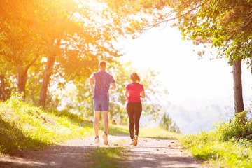 young couple jogging on sunny day at nature