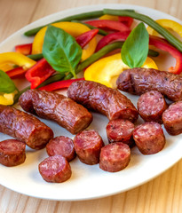 Smoked sausage with vegetables salad on a wooden board