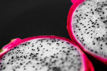 Dragon fruit. Vibrant Dragon Fruit on black background. Sliced white dragon fruit or pitaya on...