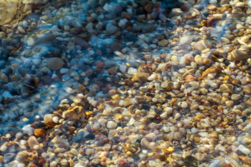 Fototapeta na wymiar sea pebbles colored granite on the beach