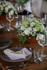 The beautiful arrangement on the wooden table, white roses and ceramic plates. Boho chic wedding table setting.