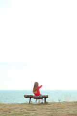 Naklejka na ściany i meble woman sitting on a chair on the beach