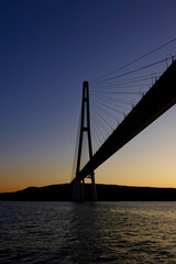 The silhouette of the cable-stayed bridge in Vladivostok, a beautiful view of the sunset