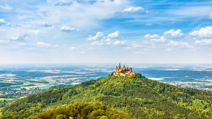 Landscape with Hohenzollern Castle, Germany. This fairytale castle is a famous landmark near Stuttgart. Scenic panorama of mount Burg Hohenzollern under blue sky. Scenery of Swabian Alps in summer.