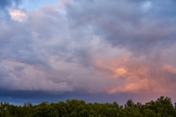 Orgous multicolored clouds looming over the forest