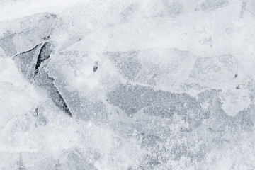 Close-up of snow on cracked and thin layers of ice in the winter. Simple and minimal full frame...