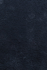 Close-up of a plastered and rough wall painted in black. High resolution full frame textured background.