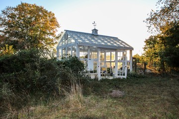 Beautiful Victorian Style Greenhouse built of  old recycled windows with a decorated interior with a large soaking tub and stenciled floor