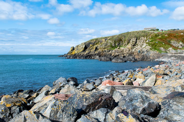 Cliffs and view of Irish Sea at sunny day in Portpatrick in Scotland. Scenic view of ocean and cliffs in Dumfries and Galloway. Beautiful seaside in Scotland. Blue sky. Sunny day.