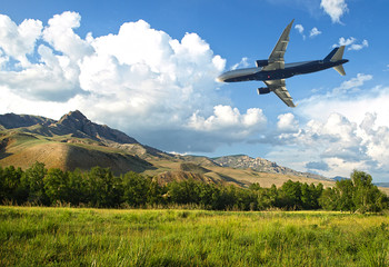 Fototapeta na wymiar the plane in the sky flies to the beautiful scenery in the mountain resort.