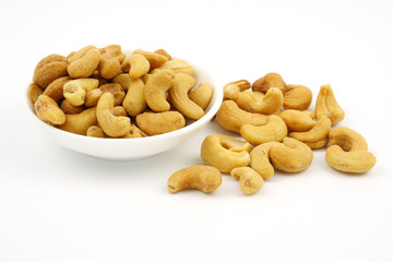Roasted cashew nuts with salt in dish isolate on white background