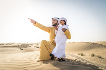Arabian man and son playing in the desert