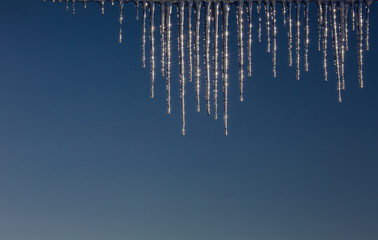 Winter icicles on a background of the early sun frosty morning