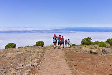 People walking in a trekking path above clouds (Madeira, Portugal) - obrazy, fototapety, plakaty