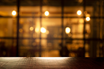 top of wood table with blur orange light of pub in bar in the dark night background