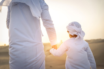Arabian man and son playing in the desert