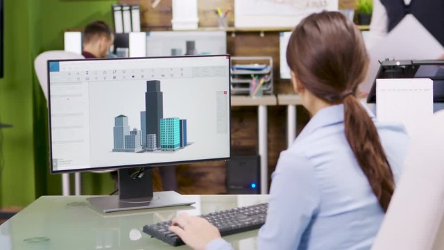 Female architect making 3d building models on computer
