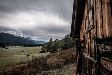 Hütte im Voralpenland mit Gebirge im Hintergrund