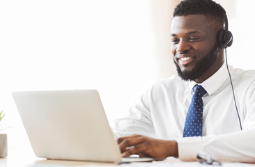 Young business consultant typing email to client on laptop