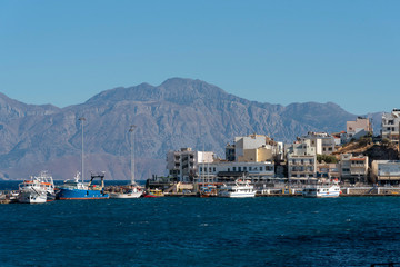 Fototapeta na wymiar Agios Nikolaos, Crete, Greece. October 2019. The waterfront of this attractive town on the Gulf of Mirabello. popular with visiting holidaymakers.