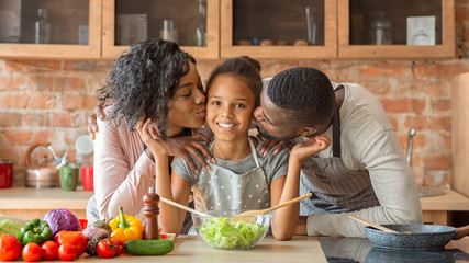 Adorable family cooking healthy dinner together at kitchen