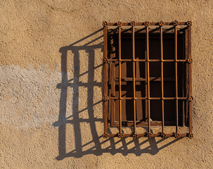 Ventana con reja proyecta sombra en muro