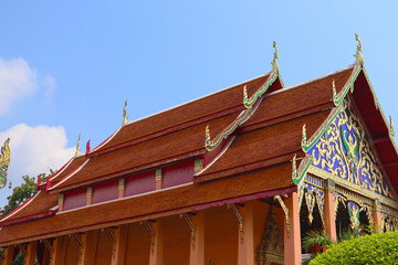 Fototapeta na wymiar Temple roof in Thailand with blue sky and white cloud as background