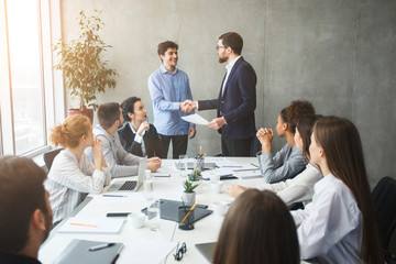 CEO congratulating successful worker by shaking hands